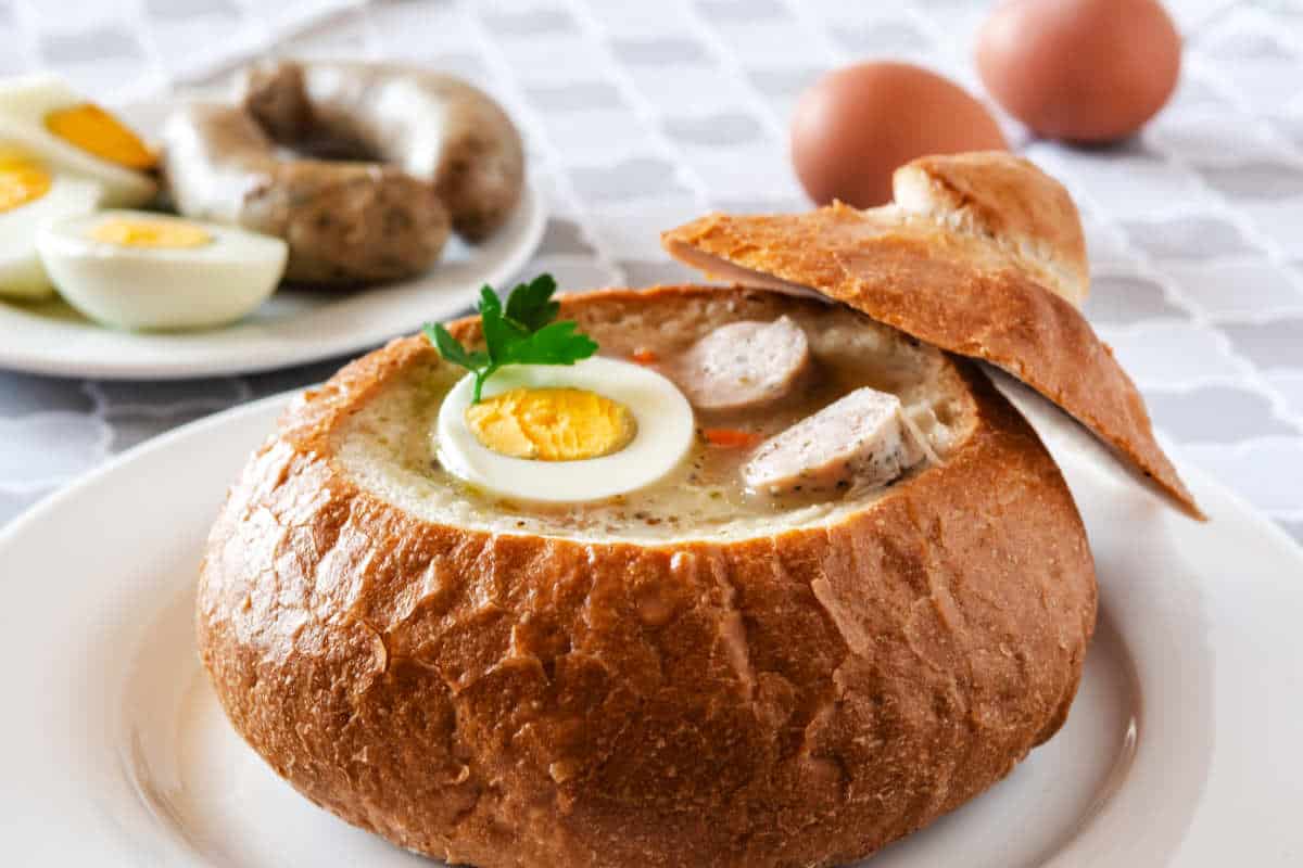 The sour soup (zurek) made of rye flour with sausage and egg served in bread bowl. Traditional polish sour rye soup, popular Easter dish.