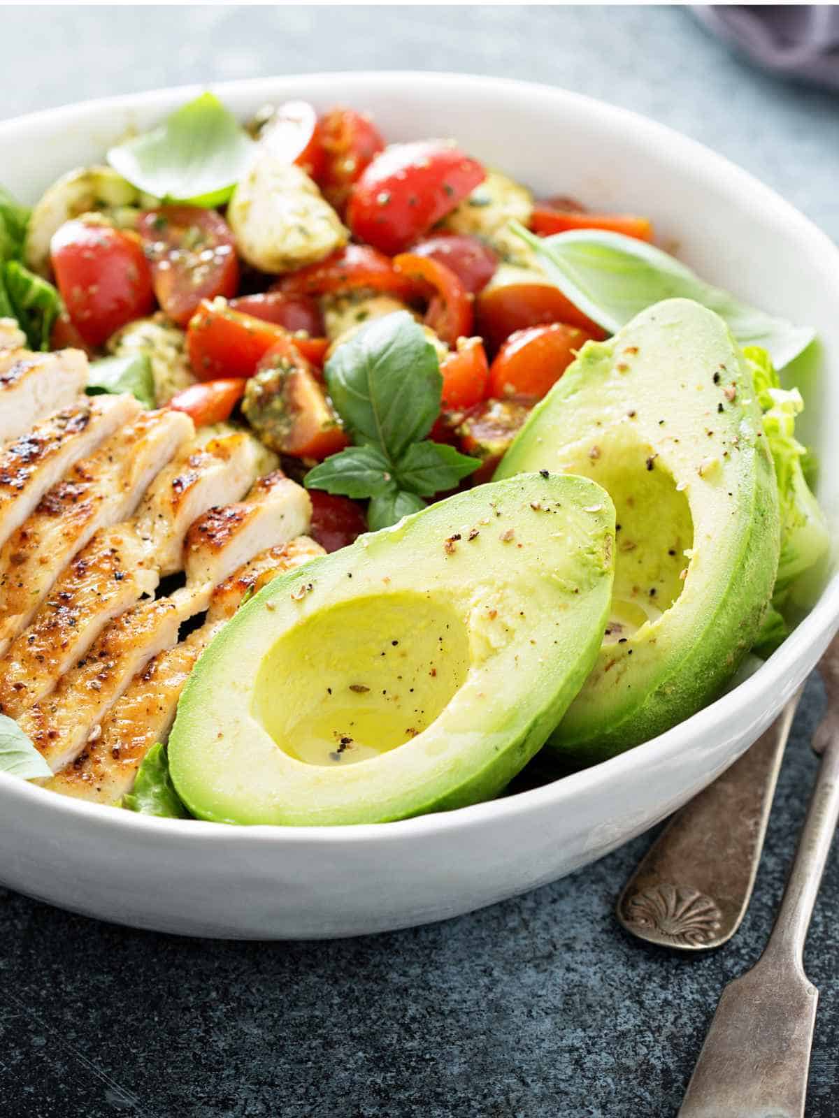 Caprese lunch bowl with grilled chicken and avocado.