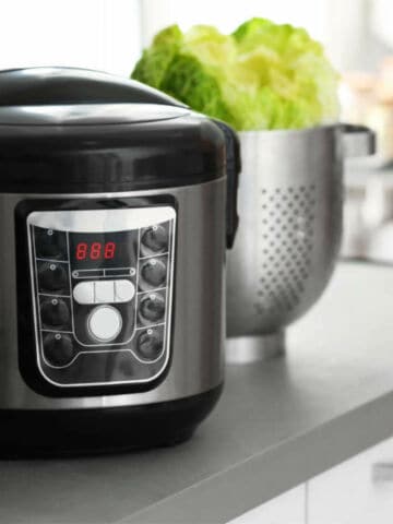 Modern electric Instant Pot multi cooker and food on kitchen countertop.