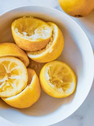 Juiced lemon halves in a bowl.