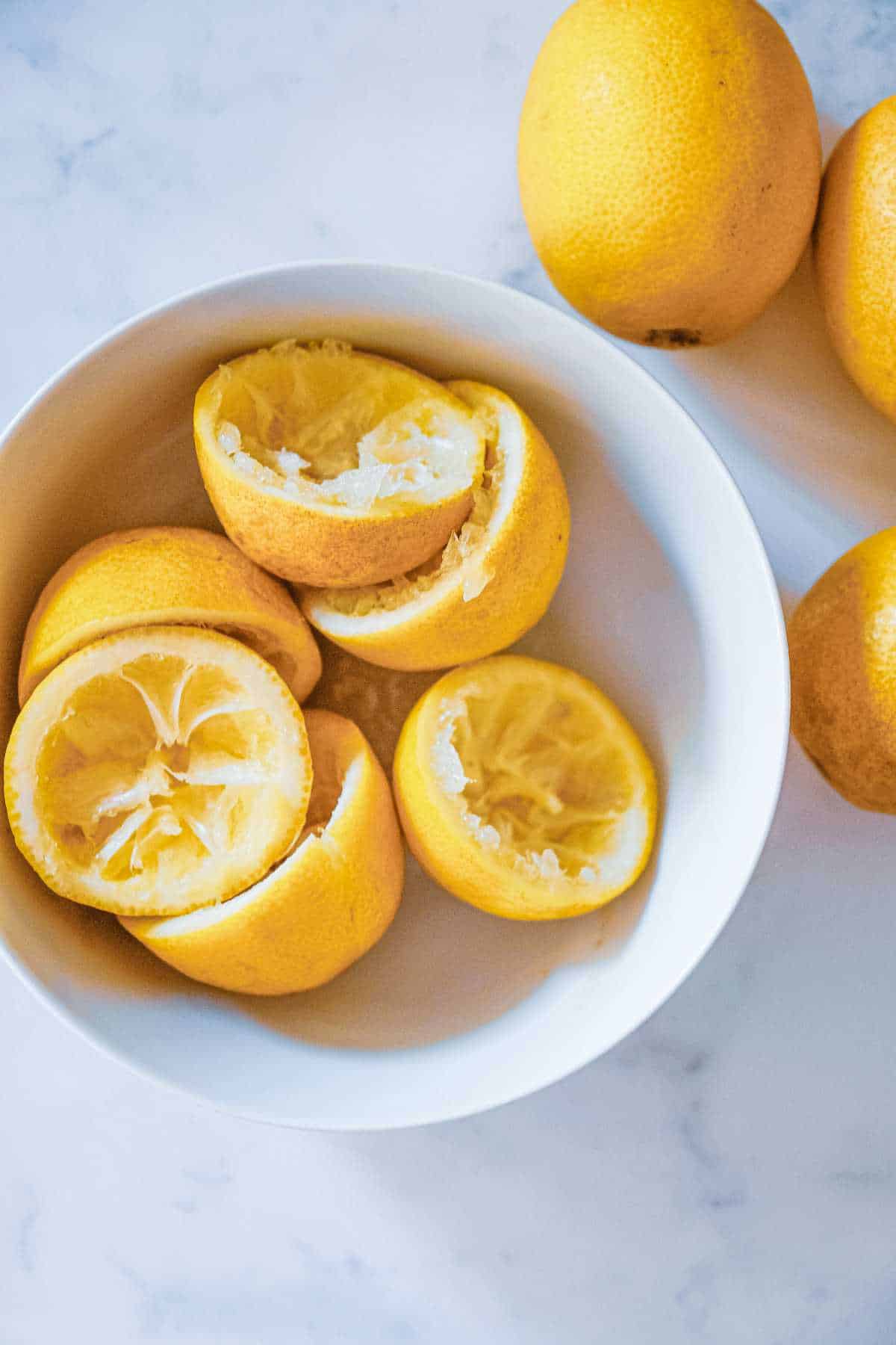 Juiced lemon halves in a bowl.