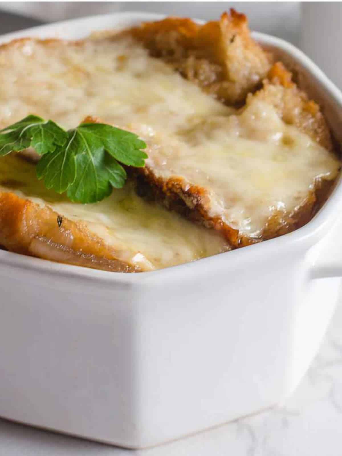 French onion soup with crusty cheese on top.