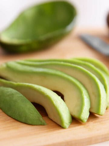 Fresh sliced avocado on cutting board.