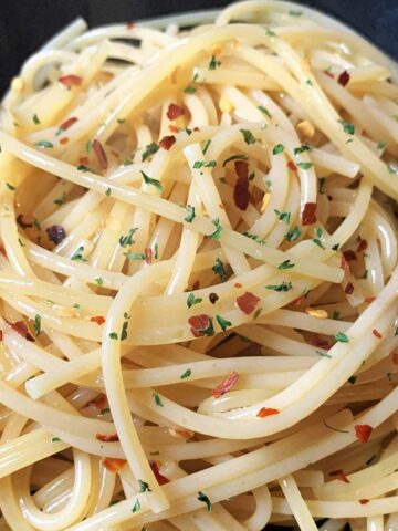 bowl of garlic and olive oil pasta with red pepper flakes.