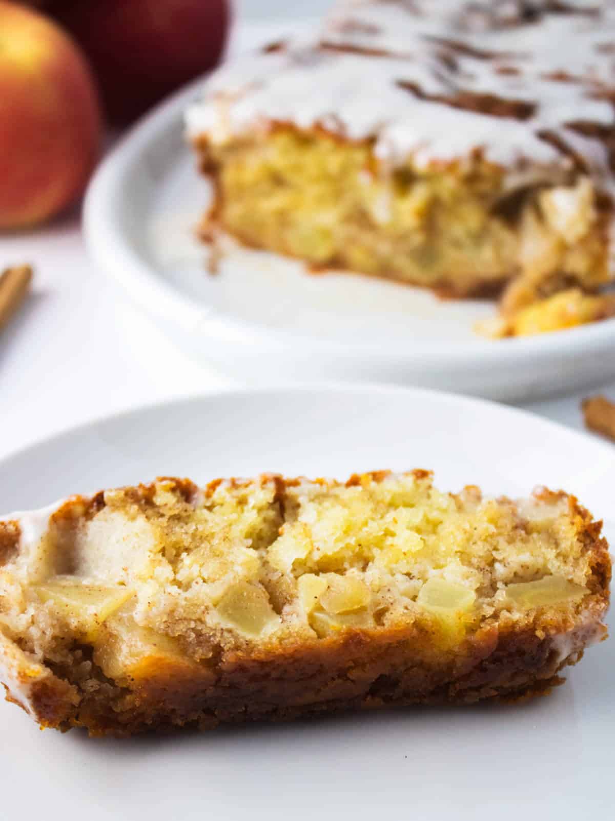 Moist apple loaf cake slice on a platter.