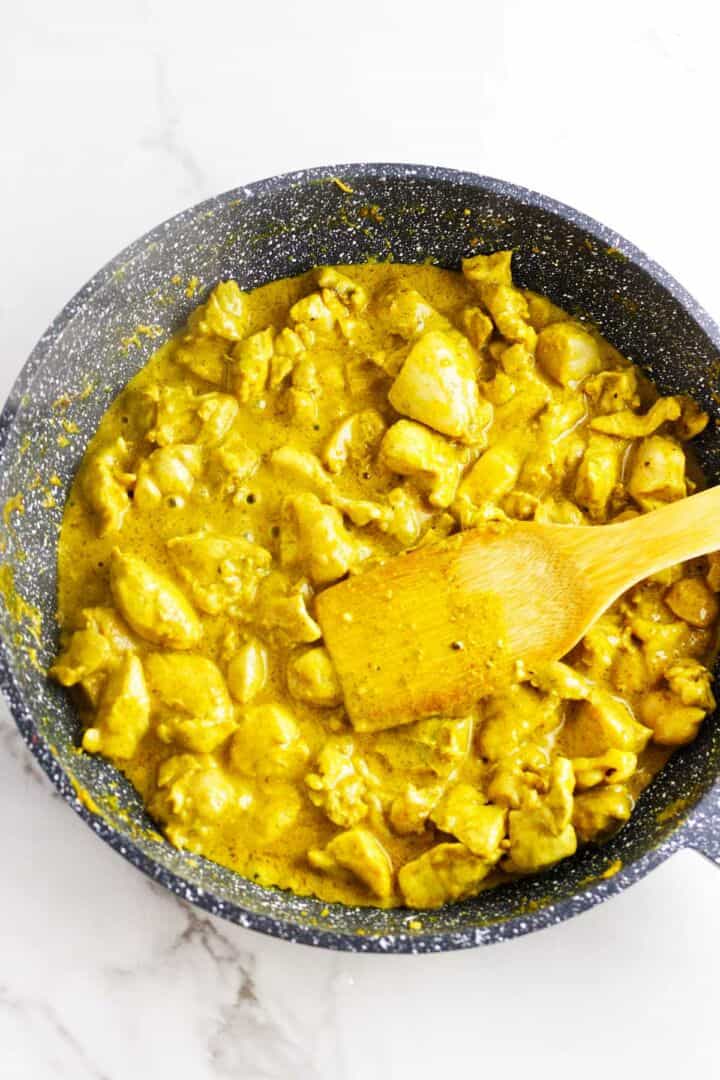 Yogurt marinated chicken sauteed in a skillet.
