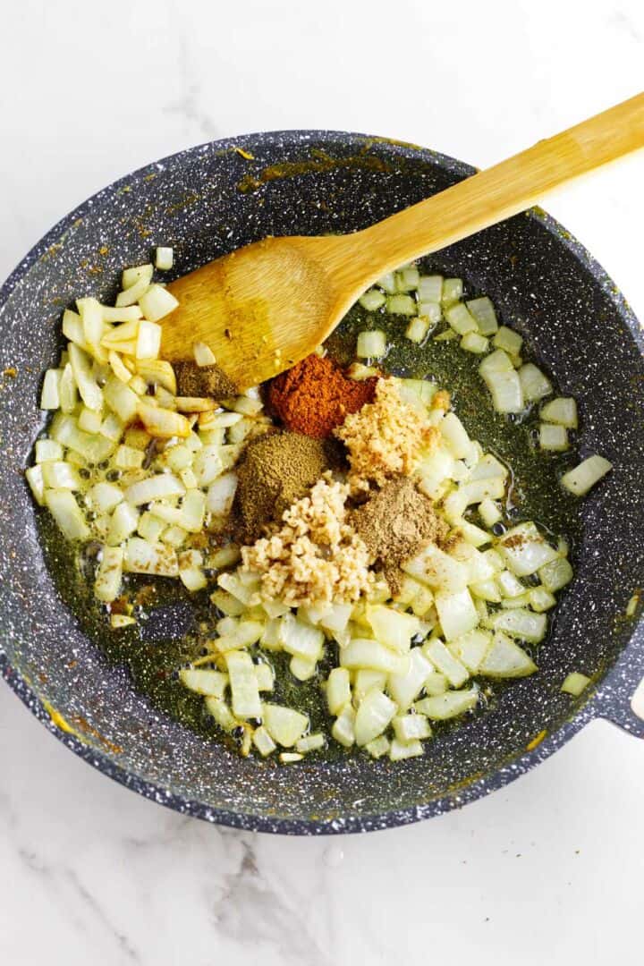 Sauteed onions and spices in a skillet.