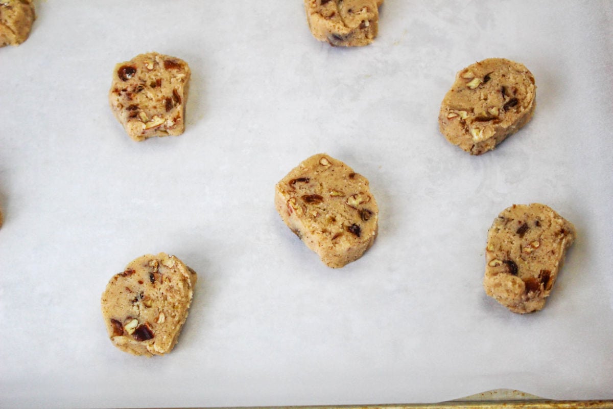 sliced chilled cookies on parchment paper for baking.