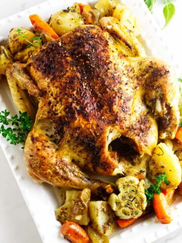 oven roasted chicken with potatoes and carrots on a platter.