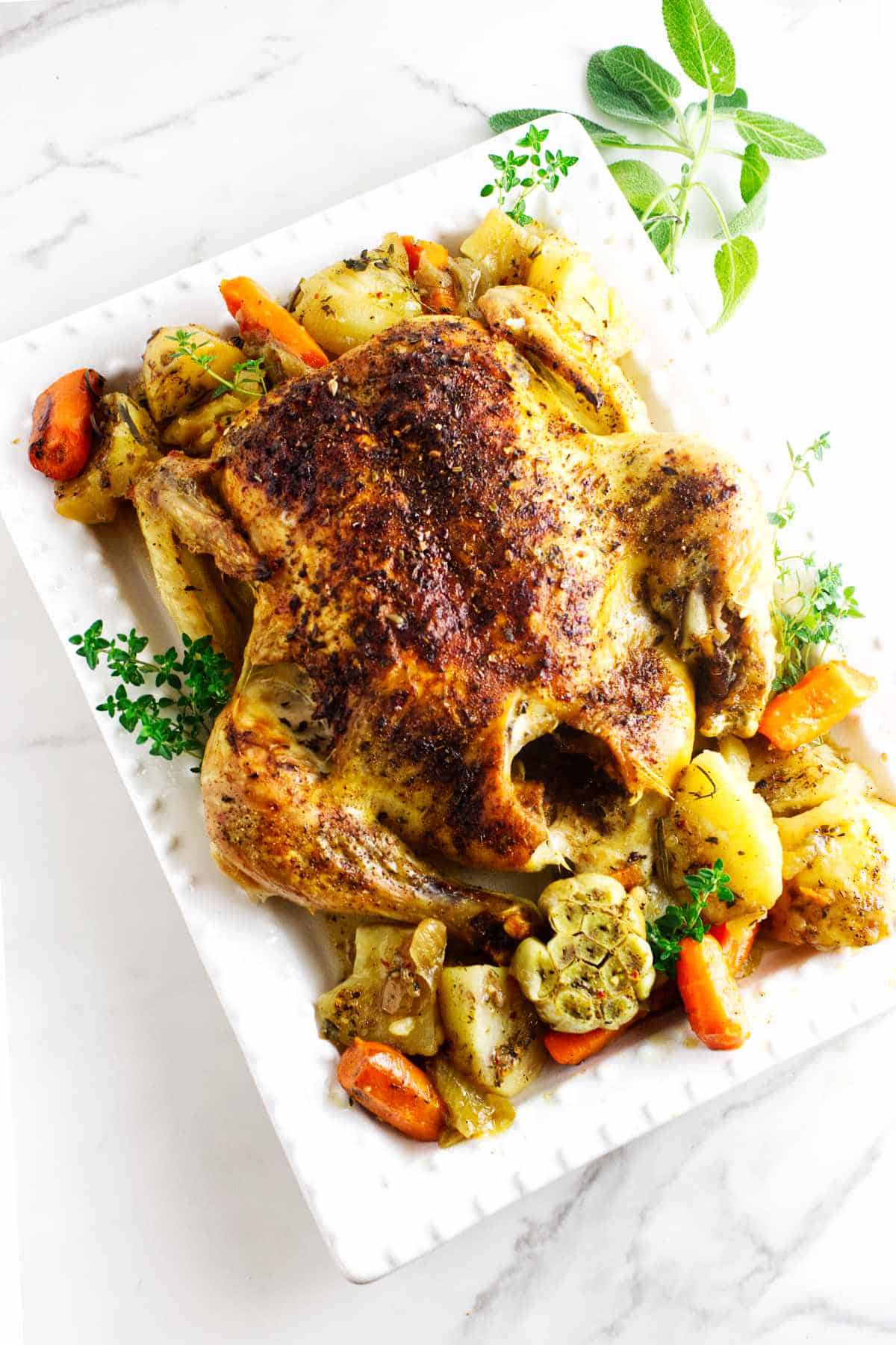 oven roasted chicken with potatoes and carrots on a platter.