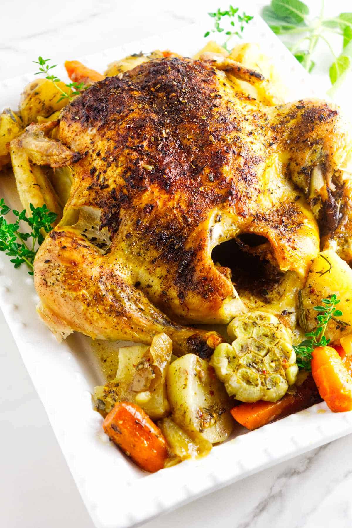 oven roasted chicken with potatoes and carrots on a platter.