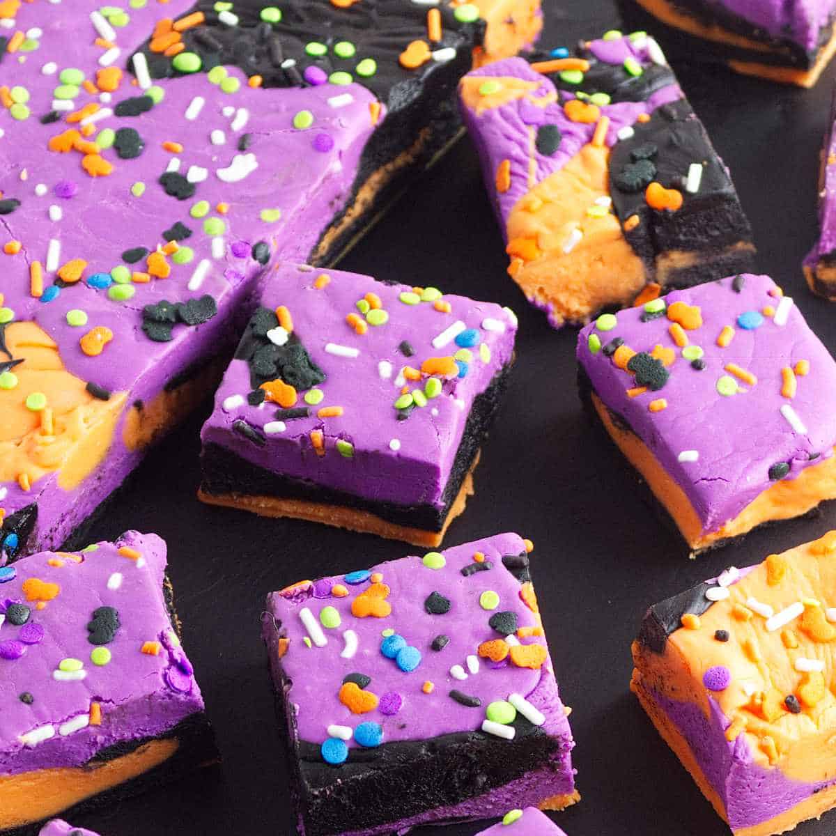 purple, orange, and black festive Halloween fudge cut into squares for serving.