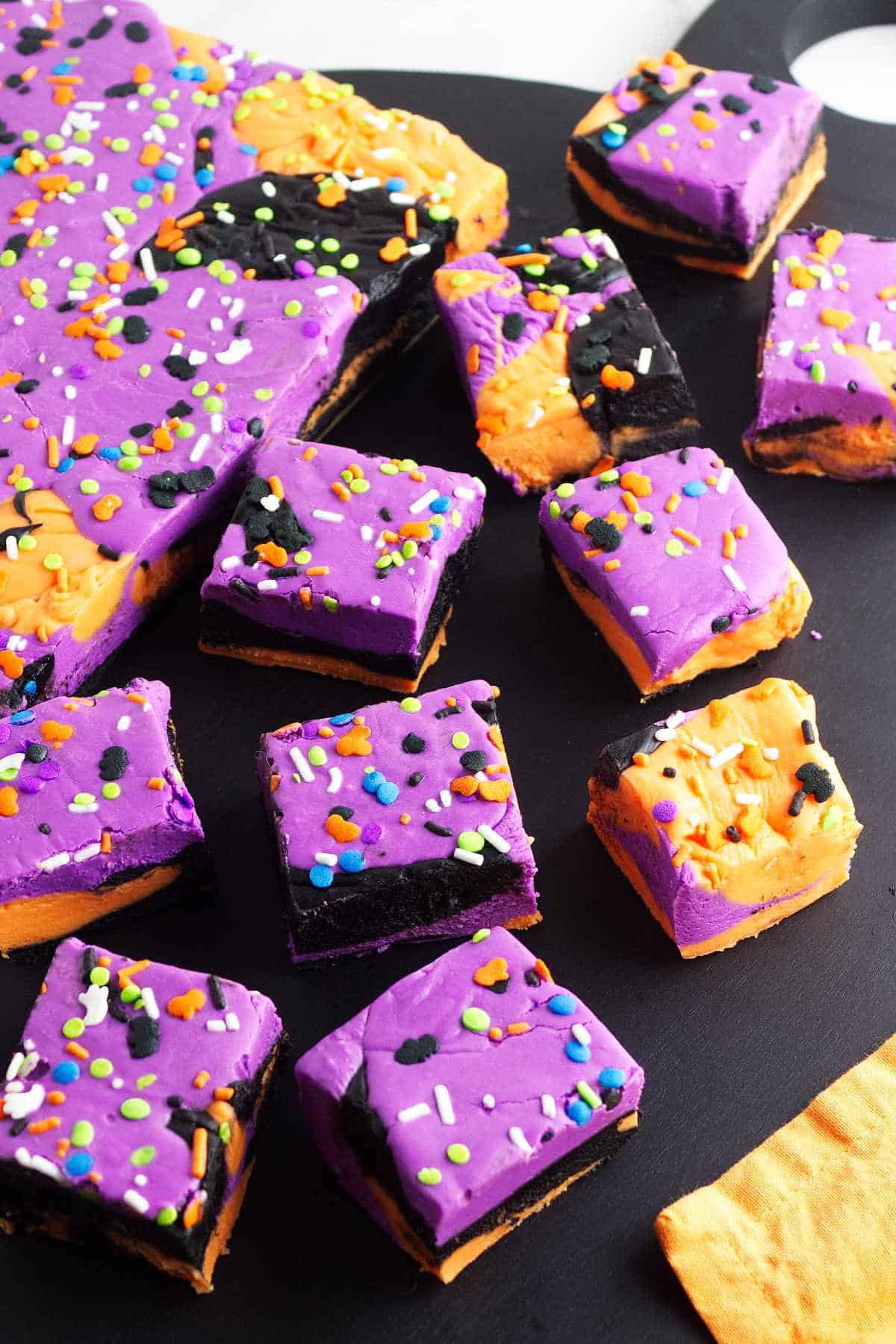 purple, orange, and black festive fudge cut into squares for serving.