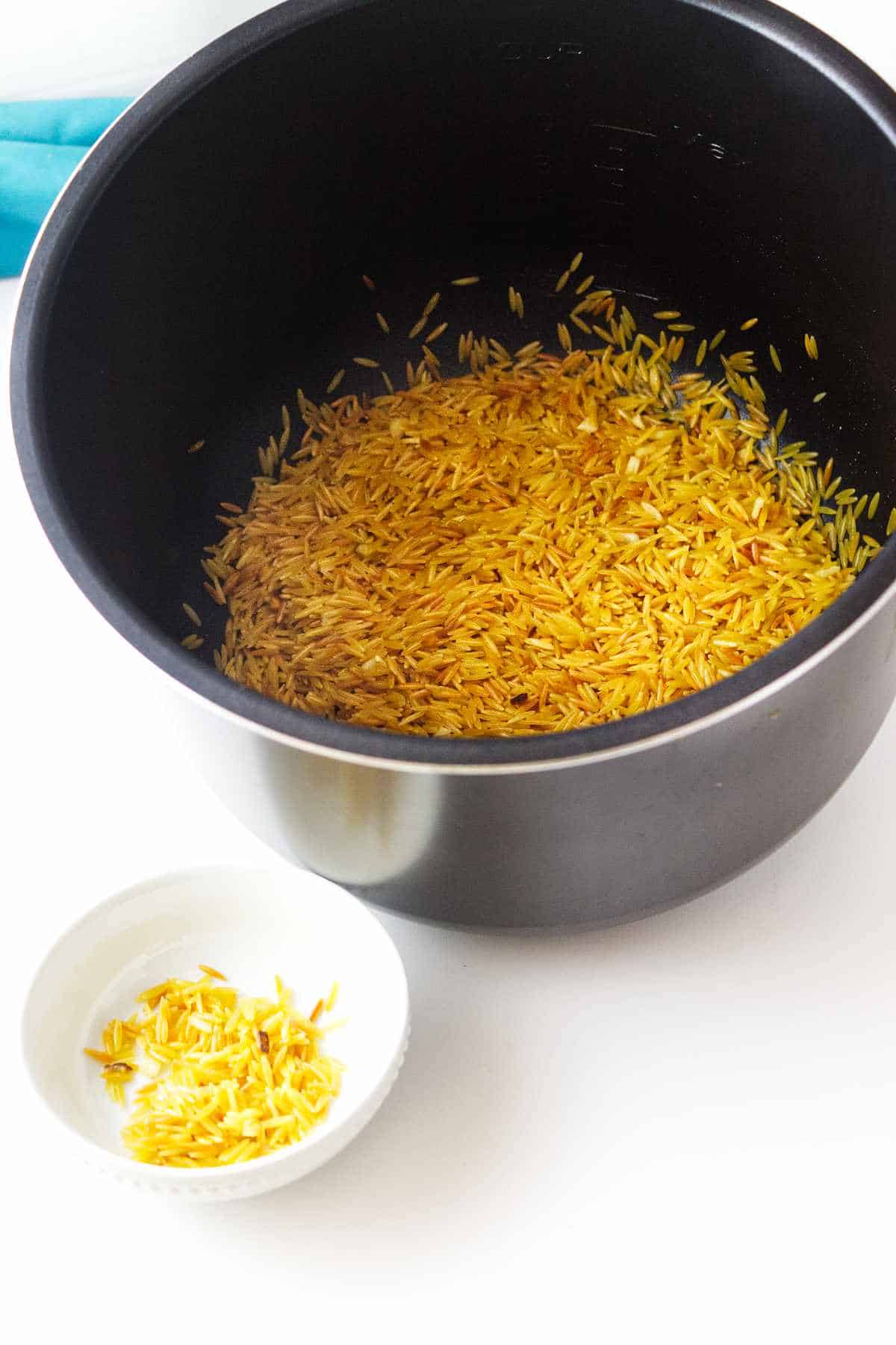 Golden brown sauteed orzo in an instant pot.