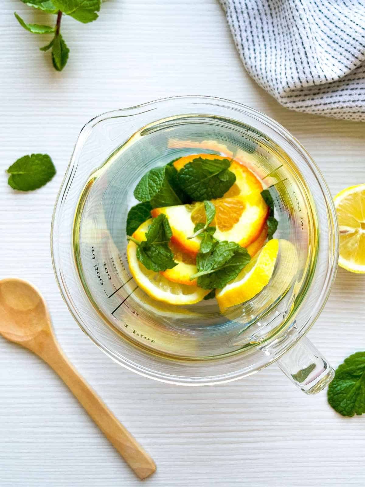 muddling mint, lemon, and orange slices.