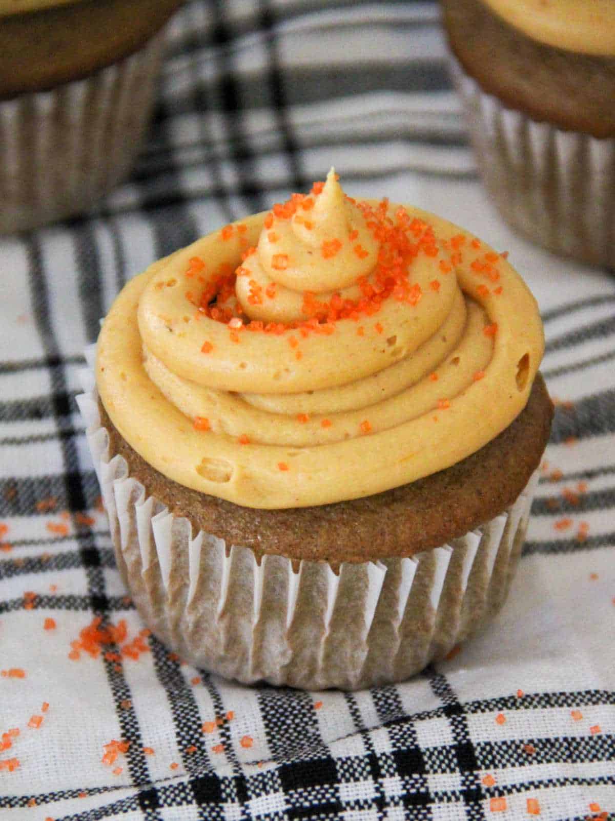 cupcakes with frosting decorated with orange sugar.