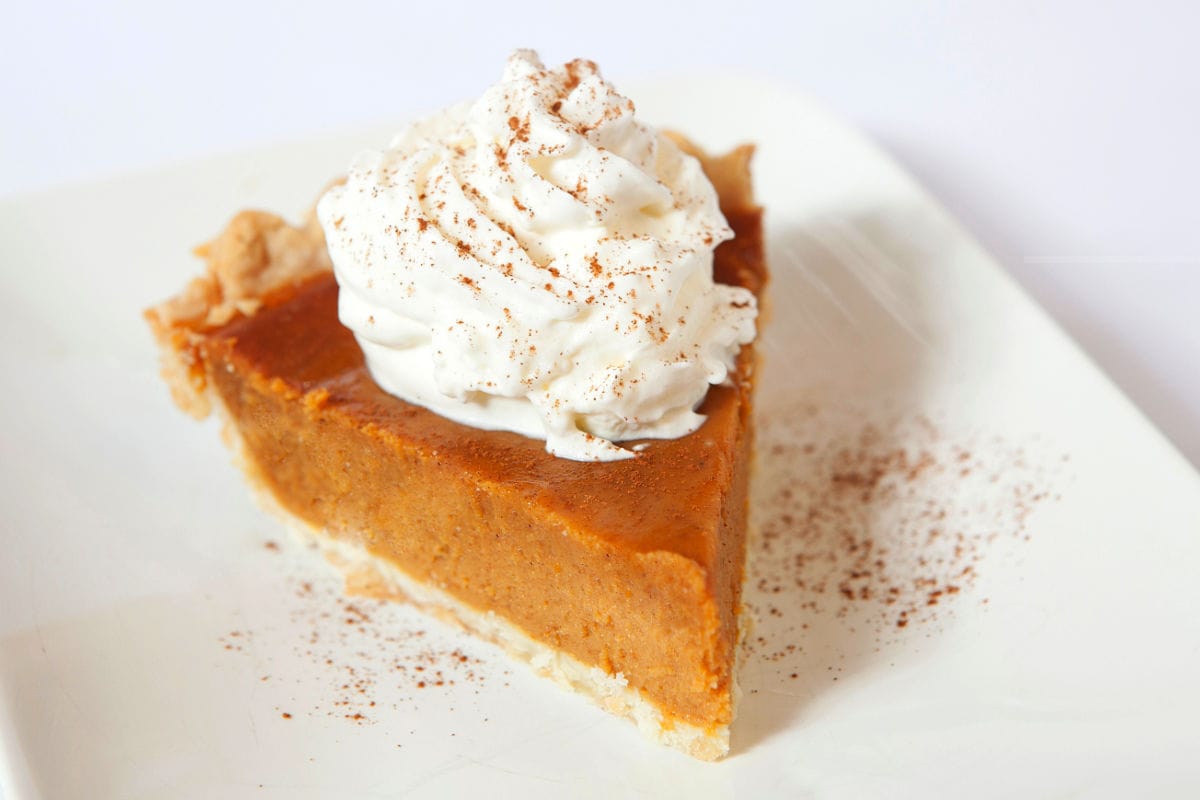 pumpkin pie without evaporated milk with whipped cream and cinnamon on top.