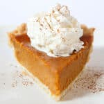 pumpkin pie without evaporated milk with whipped cream and cinnamon on top.