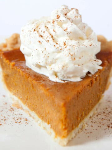 pumpkin pie without evaporated milk with whipped cream and cinnamon on top.