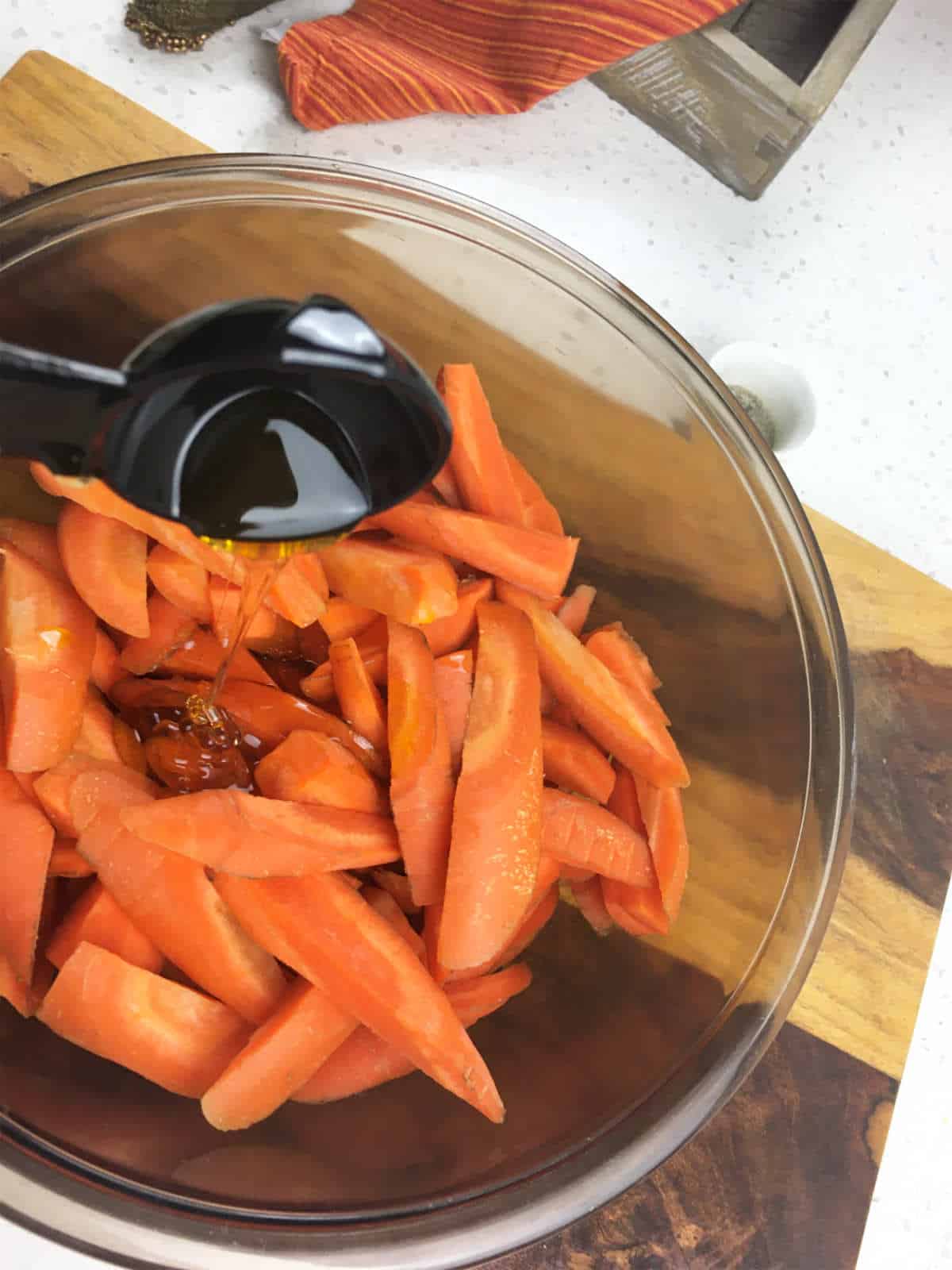 honey added to bowl of cut carrots.