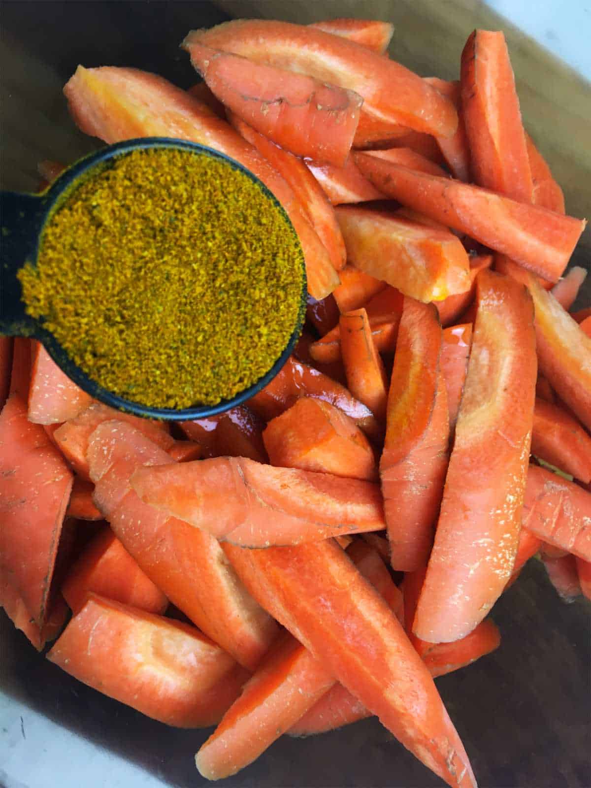 seasoning added to bowl of cut carrots.
