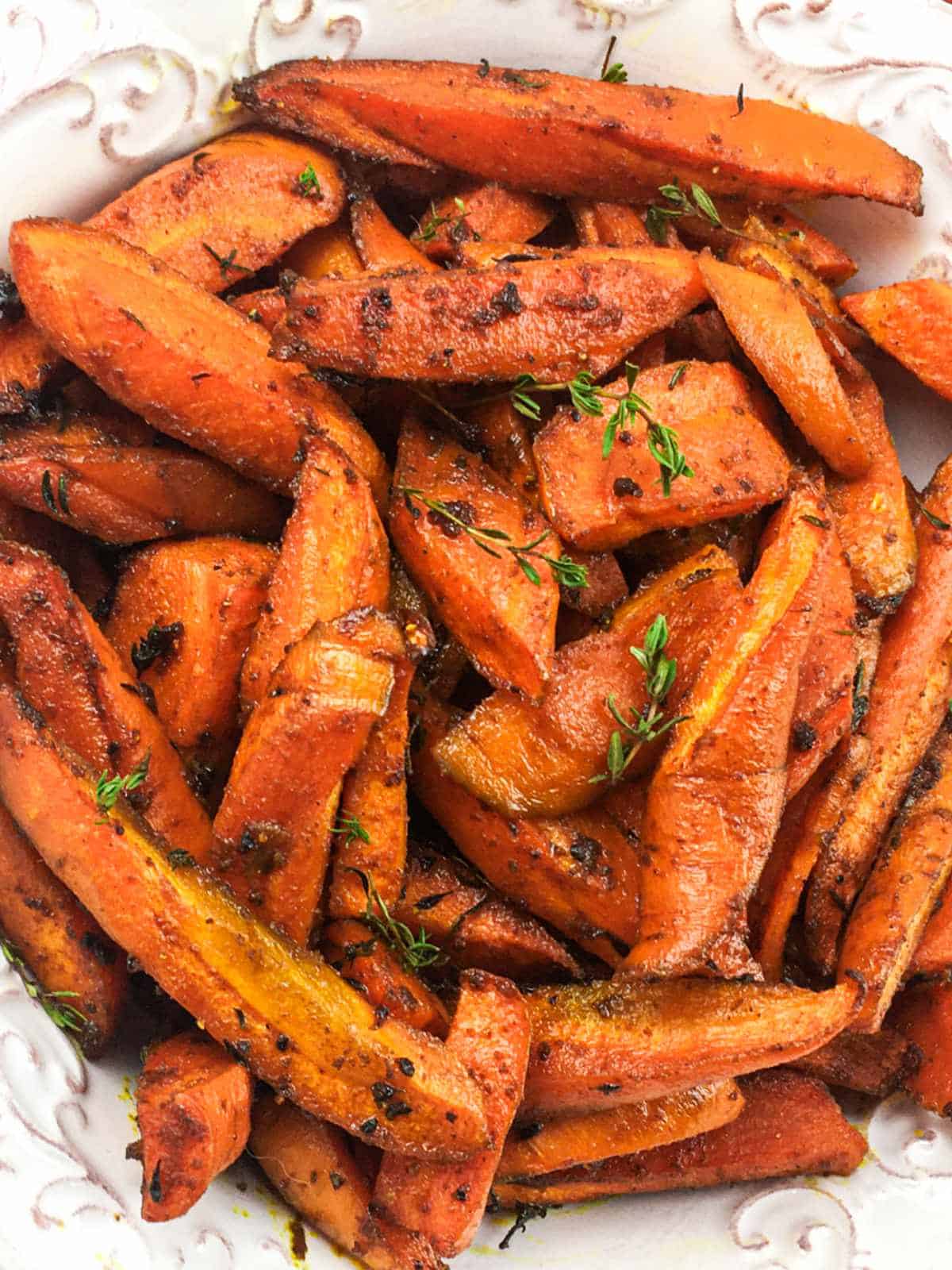roasted carrots in a bowl, garnished with fresh thyme.