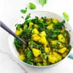 Saag aloo (spinach and potato curry) in a skillet.