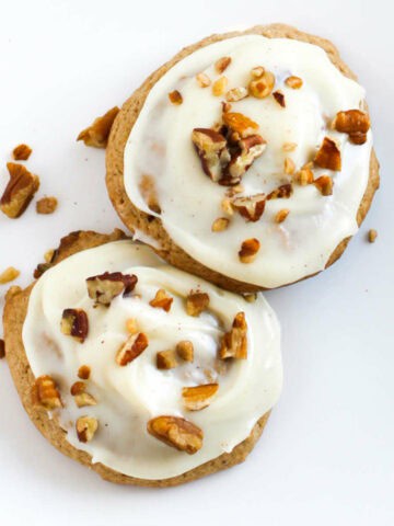 frosted spice cake cookies with chopped nuts on top.