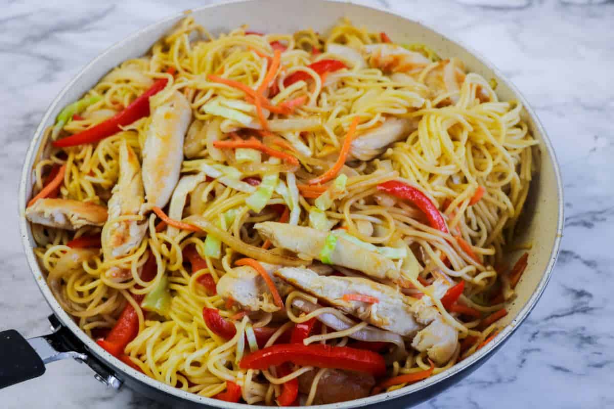 cooked chicken lo mein with noodles added.