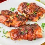 Prosciutto wrapped chicken on a plate.