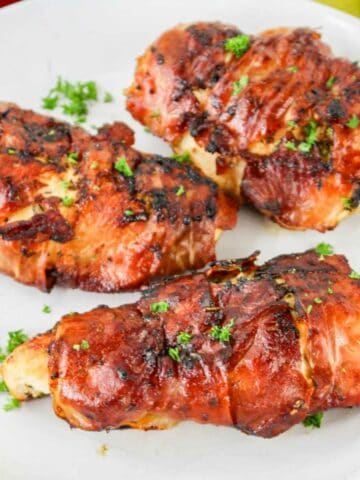 Prosciutto wrapped chicken on a plate.