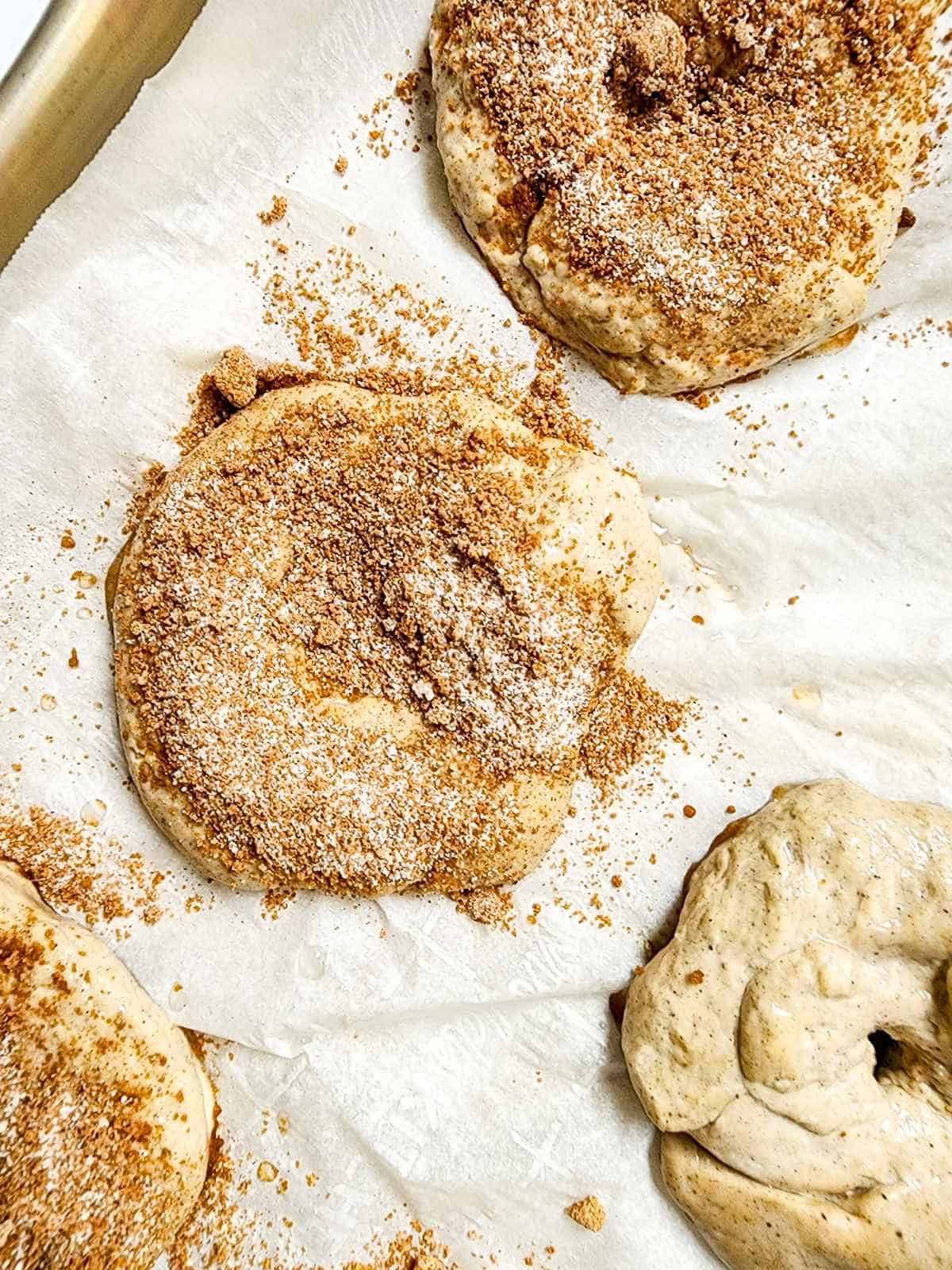 bagels on a baking sheet with cinnamon crunch topping.