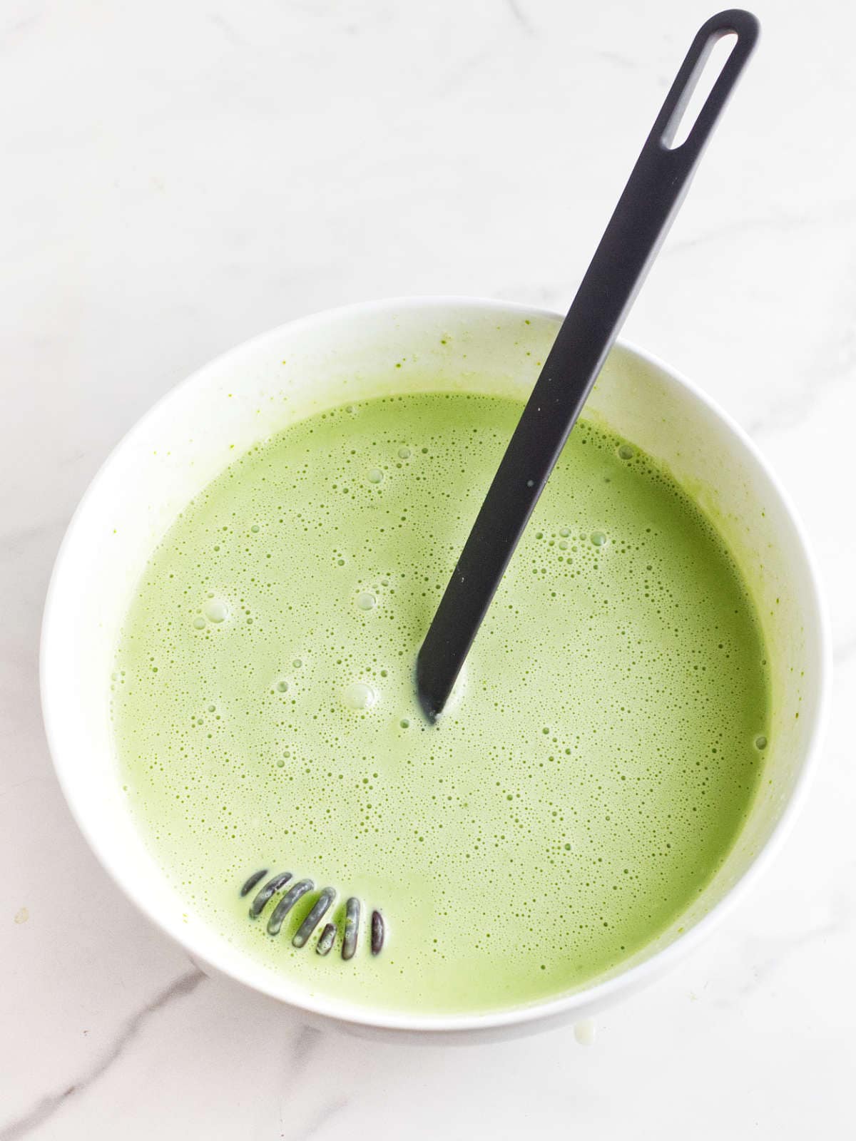 mixing in matcha into ice cream base.