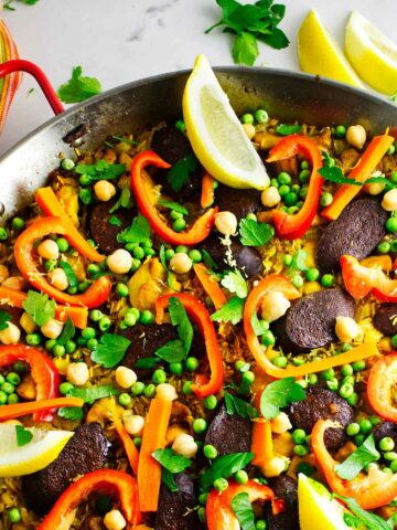 Paella Valenciana with fresh garden vegetables for garnish.