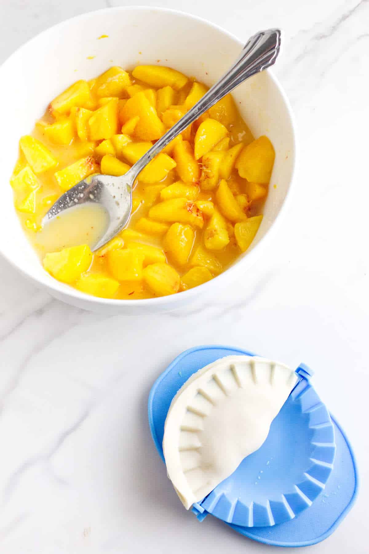 crimped peach hand pie ready to place on a baking sheet.