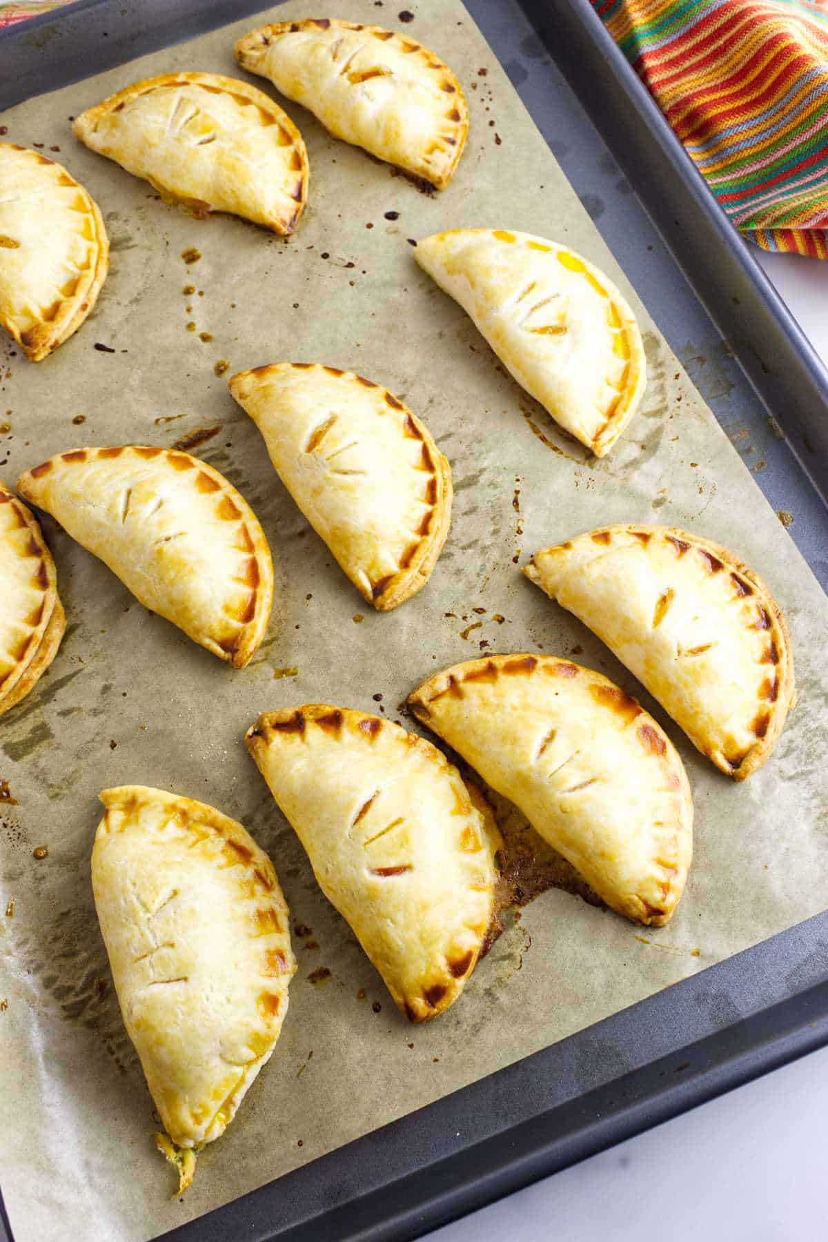Peach hand pies on a baking sheet golden brown.