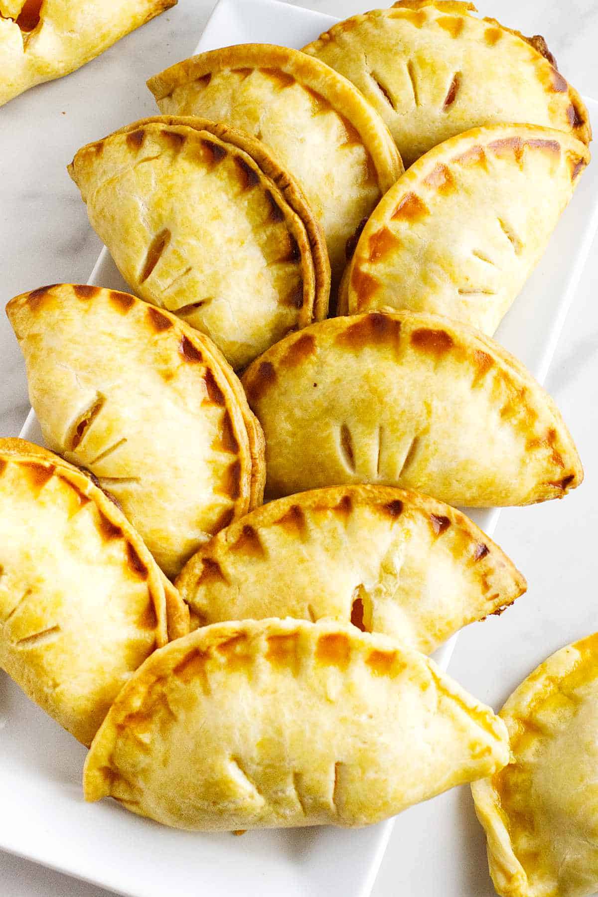 golden brown peach hand pies on a serving platter.