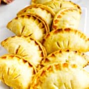 golden brown peach hand pies on a serving platter.