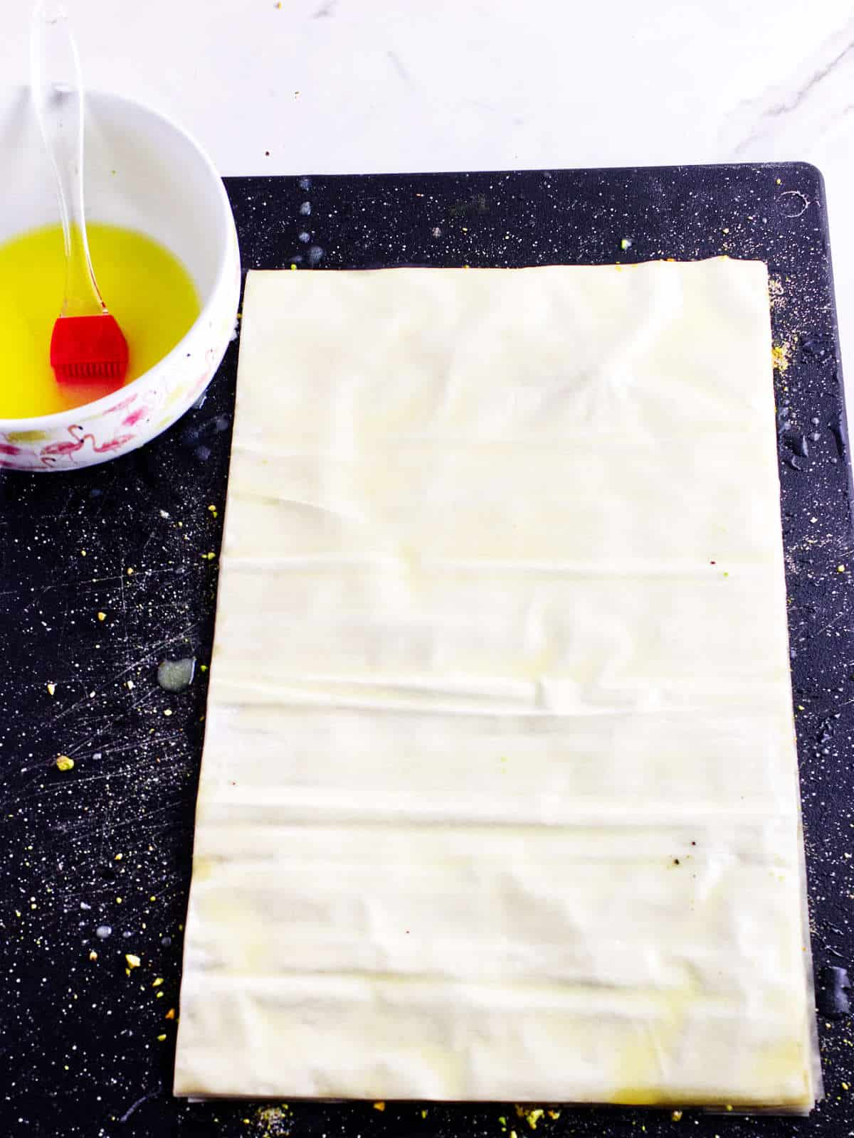 buttered phyllo dough on a cutting board.