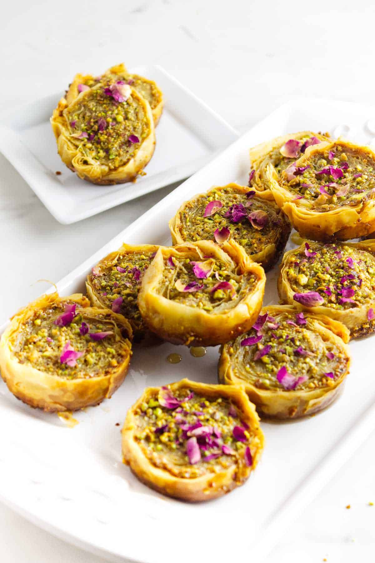 pistachio baklava garnished with chopped pistachios and rose petals.