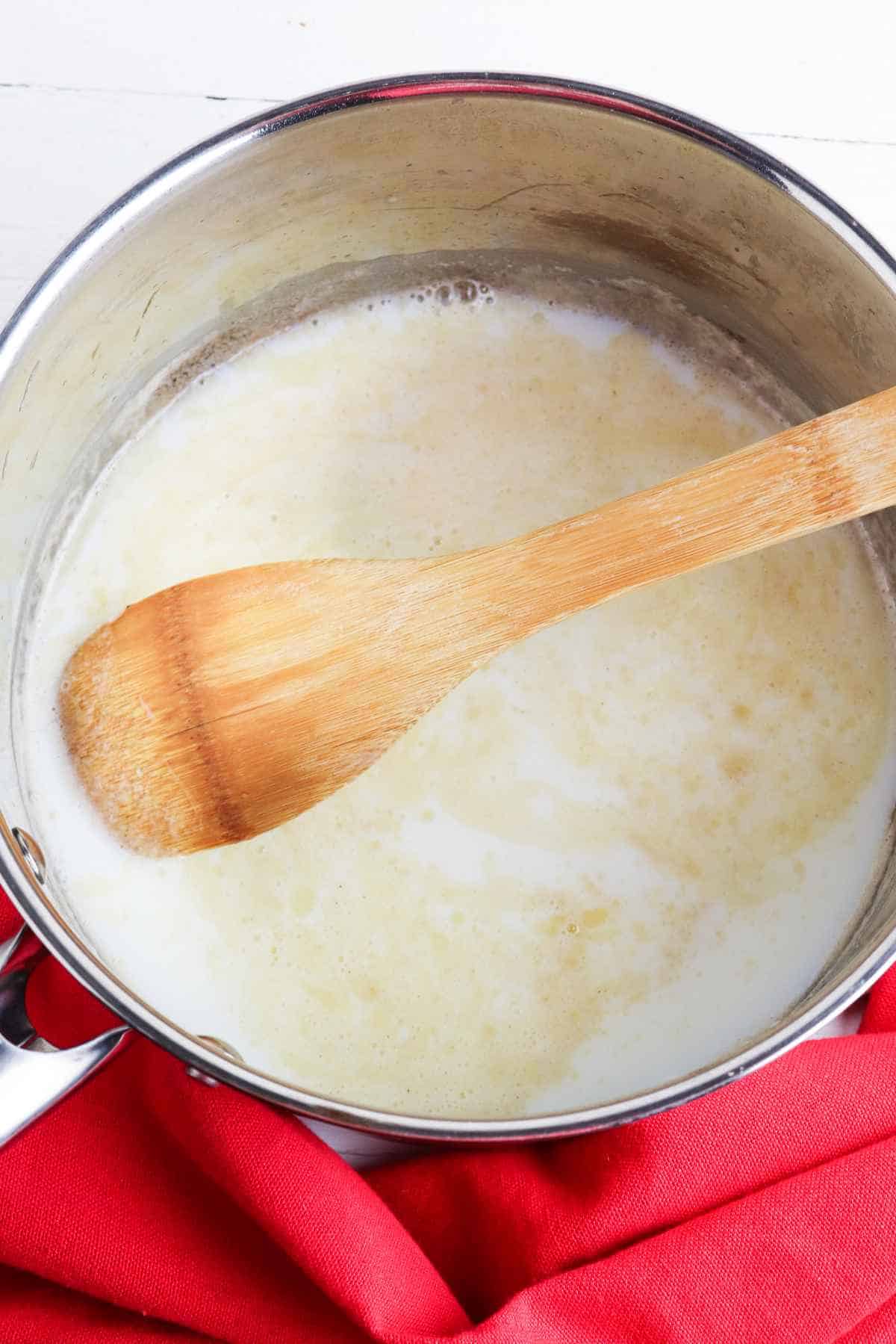 butter melting with milk and flour in a sauce pan.