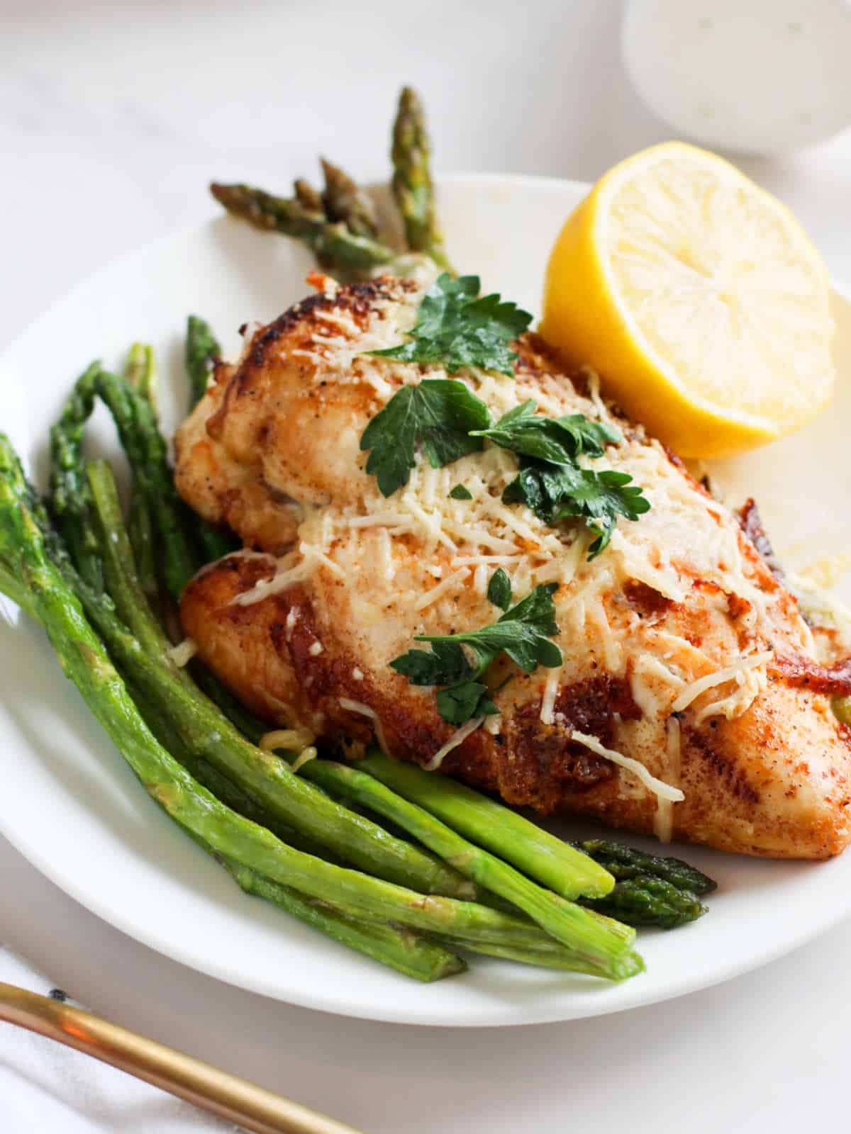 plate with roasted asparagus and cheese stuffed chicken breasts.