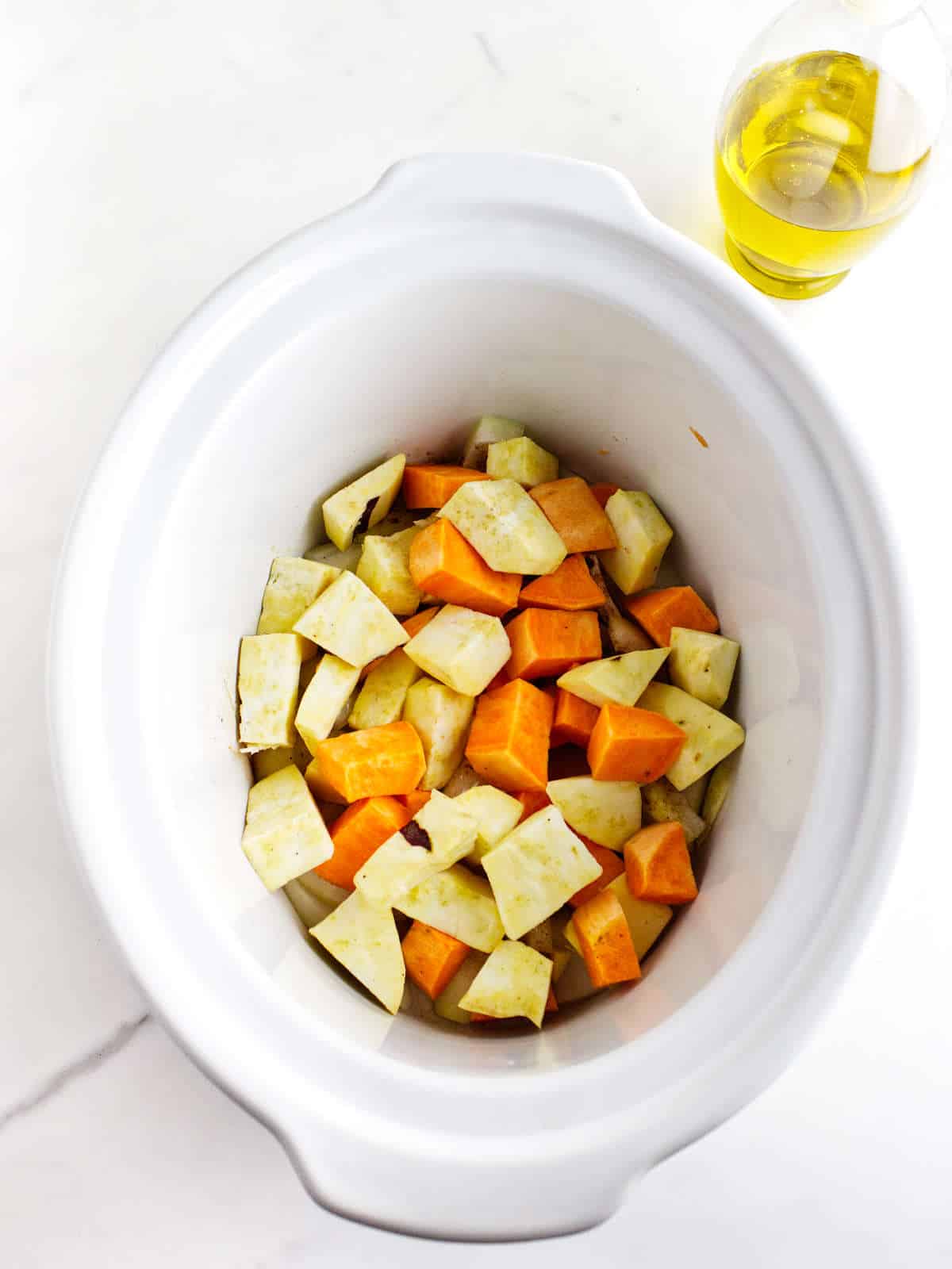 white and orange diced sweet potatoes added to the slow cooker.