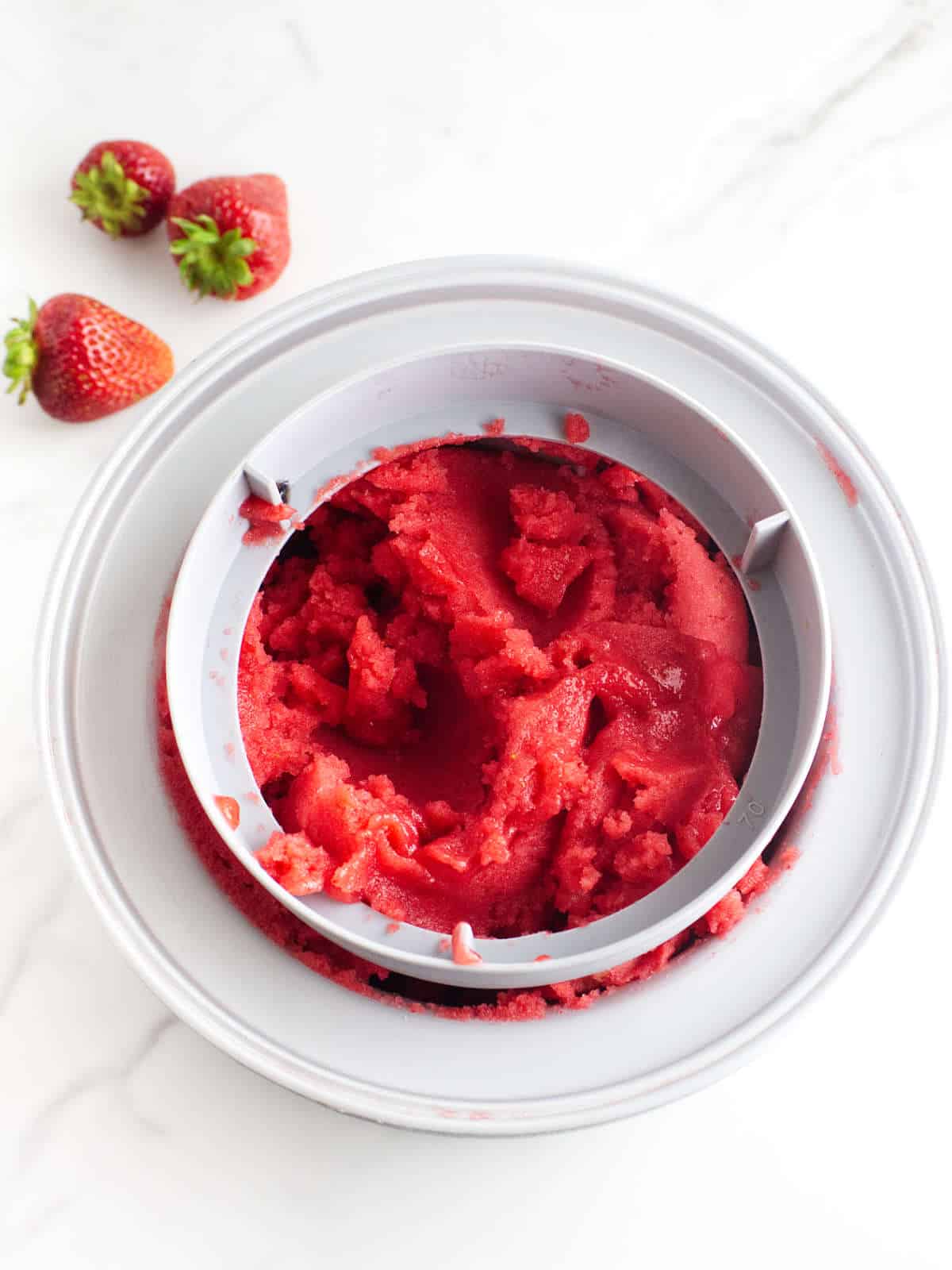 Cuisinart freezer bowl with strawberry sorbet inside, ready to transfer to storage tubs.