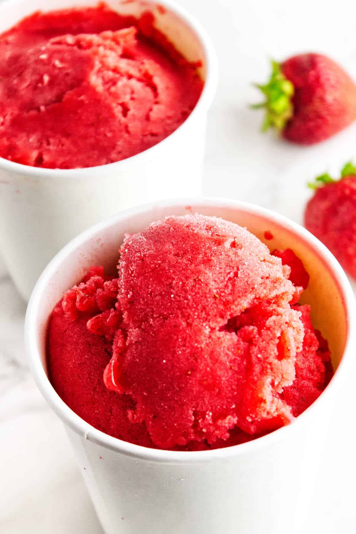 Strawberry sorbet in ice cream storage tubs.