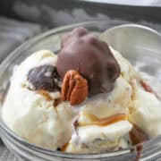 turtle ice cream in a bowl with caramel and fudge sauce.