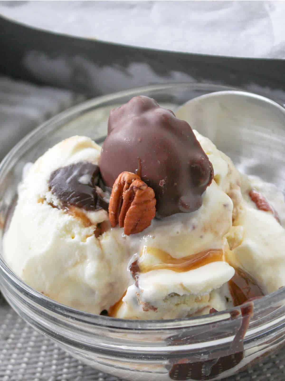 turtle ice cream in a bowl with caramel and fudge sauce.