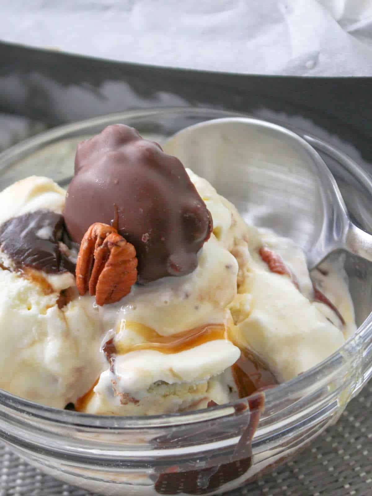 turtle ice cream in a bowl with caramel and fudge sauce.