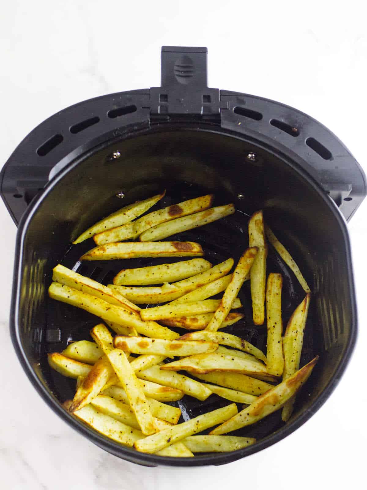 air fryer with browned crisp white sweet potato fries.