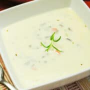 creamy wild rice soup garnished with rosemary.